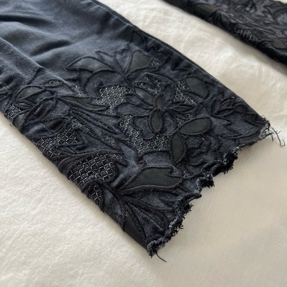 Black denim crop pants with leather and lace detail at cuffs.